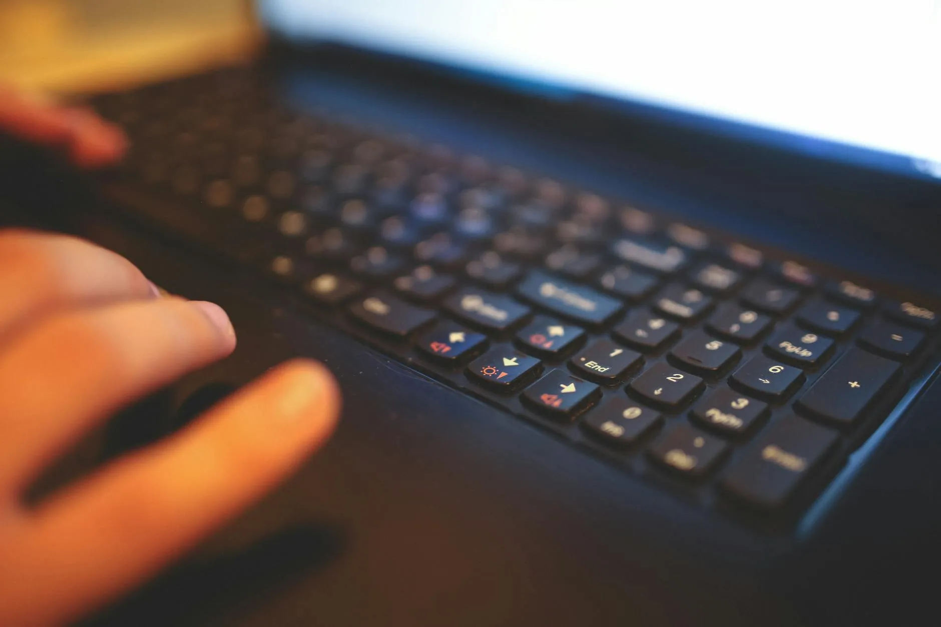 A close up shot of a student hands using a laptop next to a coffee cup in a modern university library