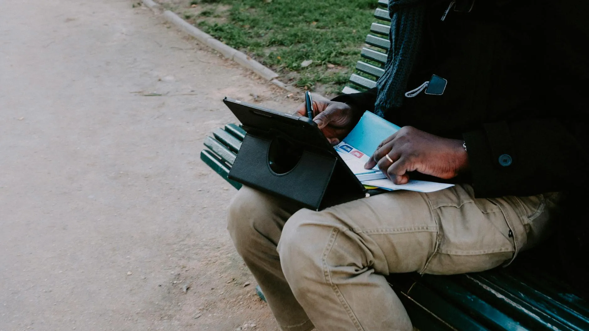 Close up of a student using a digital tablet to organize study notes on a messy desk
