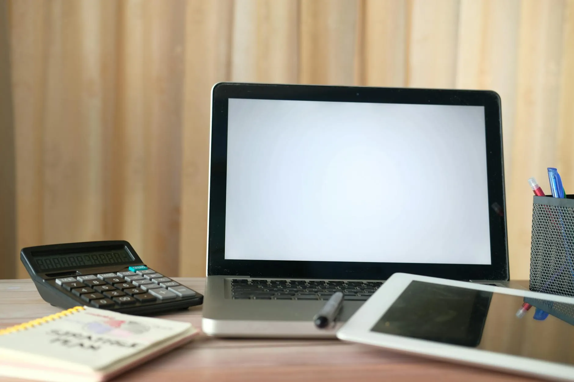Close-up of a student's hands creating digital flashcards on a tablet at a messy dorm room desk, with textbooks in the background.