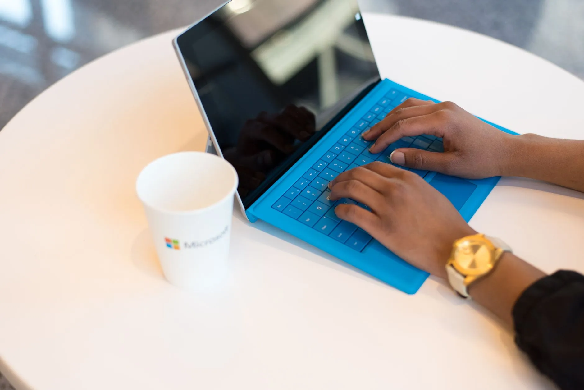 Close up of hands typing on a laptop keyboard with presentation slides on screen