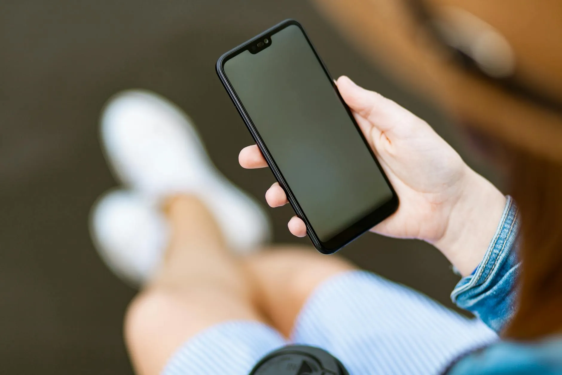 A close up shot of a student using a language learning app on their phone at a campus coffee shop