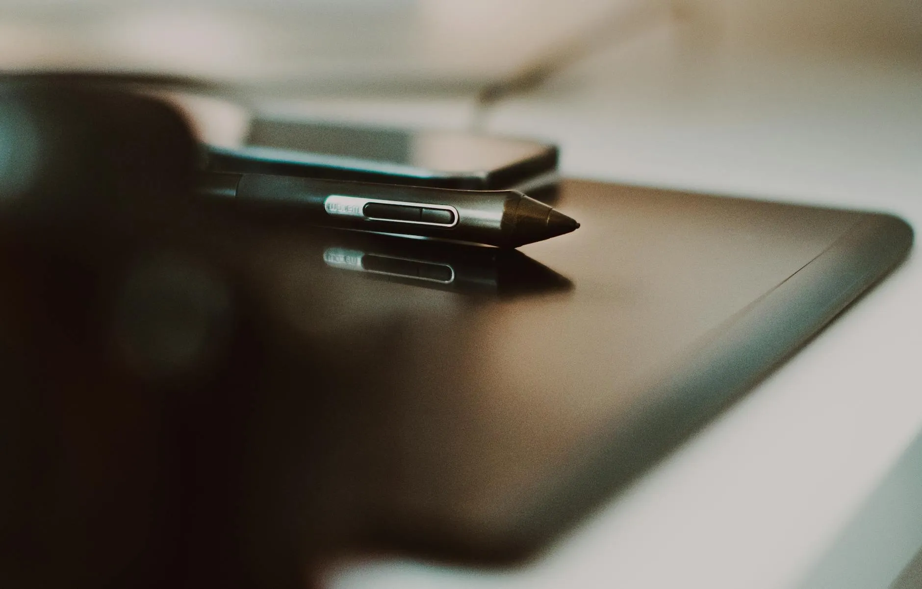 Close-up of student hands creating digital flashcards on a tablet at a cluttered dorm desk.