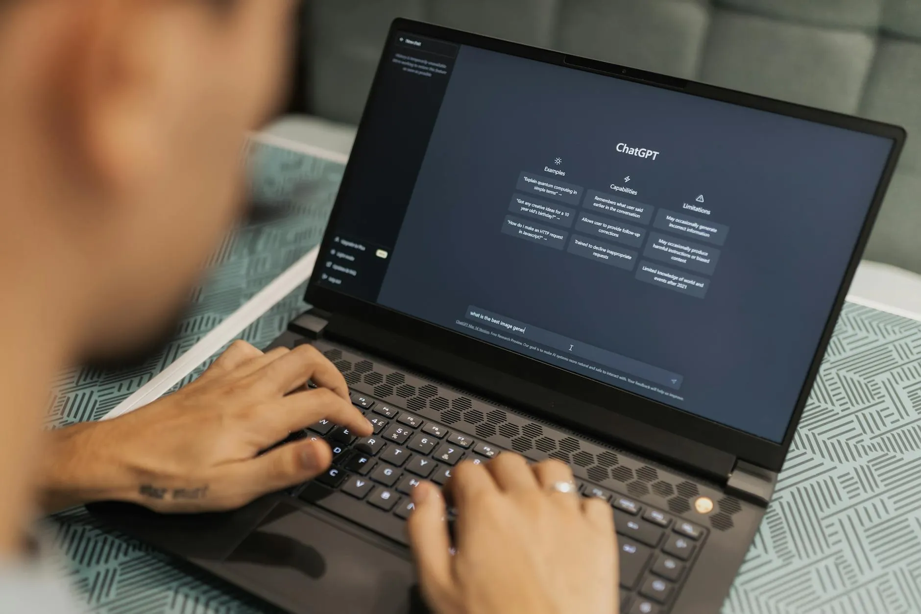 Close up of student hands typing on a laptop surrounded by notebooks and a hydro-flask