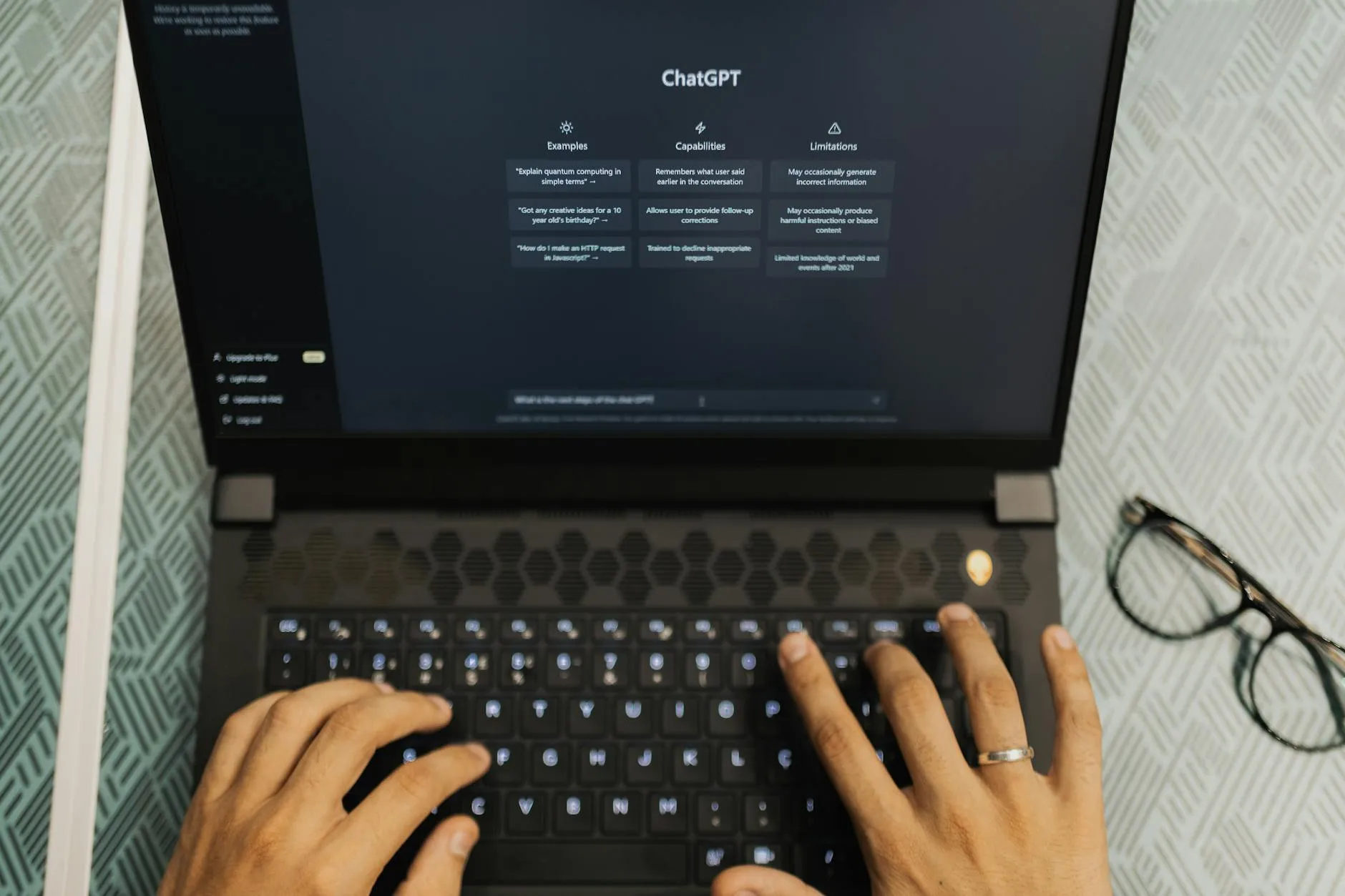 Close up of a student working on a laptop with study materials nearby