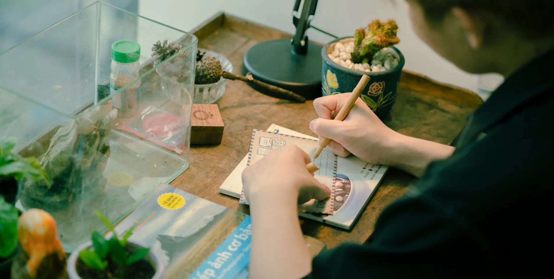 Detail shot of a student using a highlighter on a textbook at a messy desk