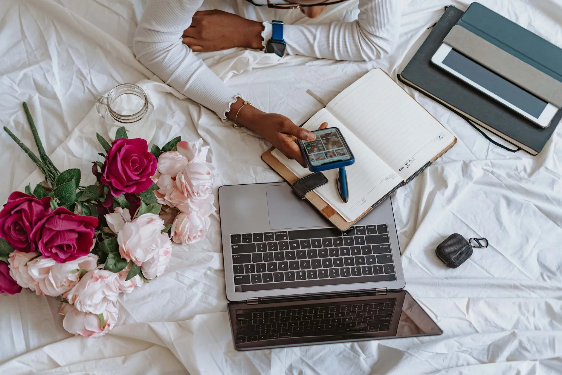 Close up of hands using a tablet to organize digital flashcards on a messy wooden dorm desk with a coffee mug