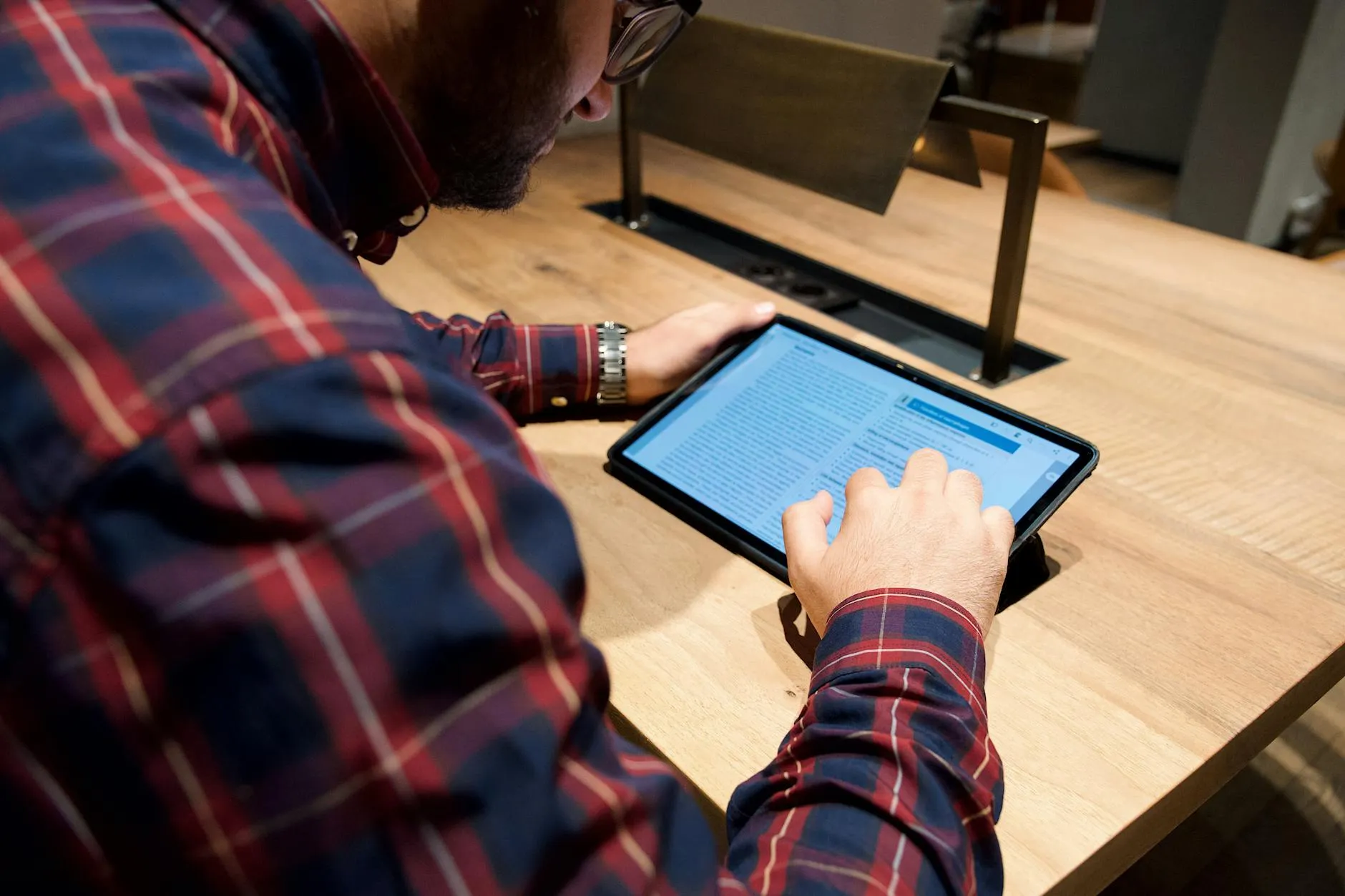 Close up of a student using a study application on a tablet at a cluttered desk