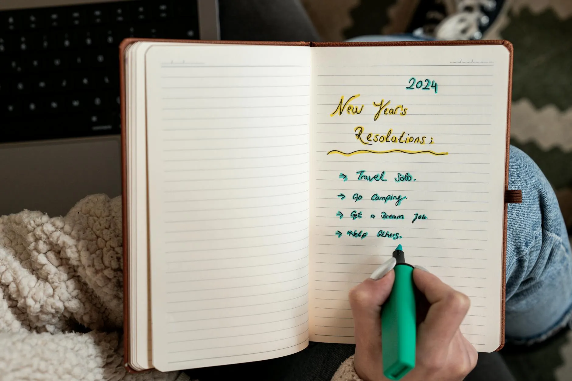 Detail shot of a student taking handwritten notes from a thick college textbook