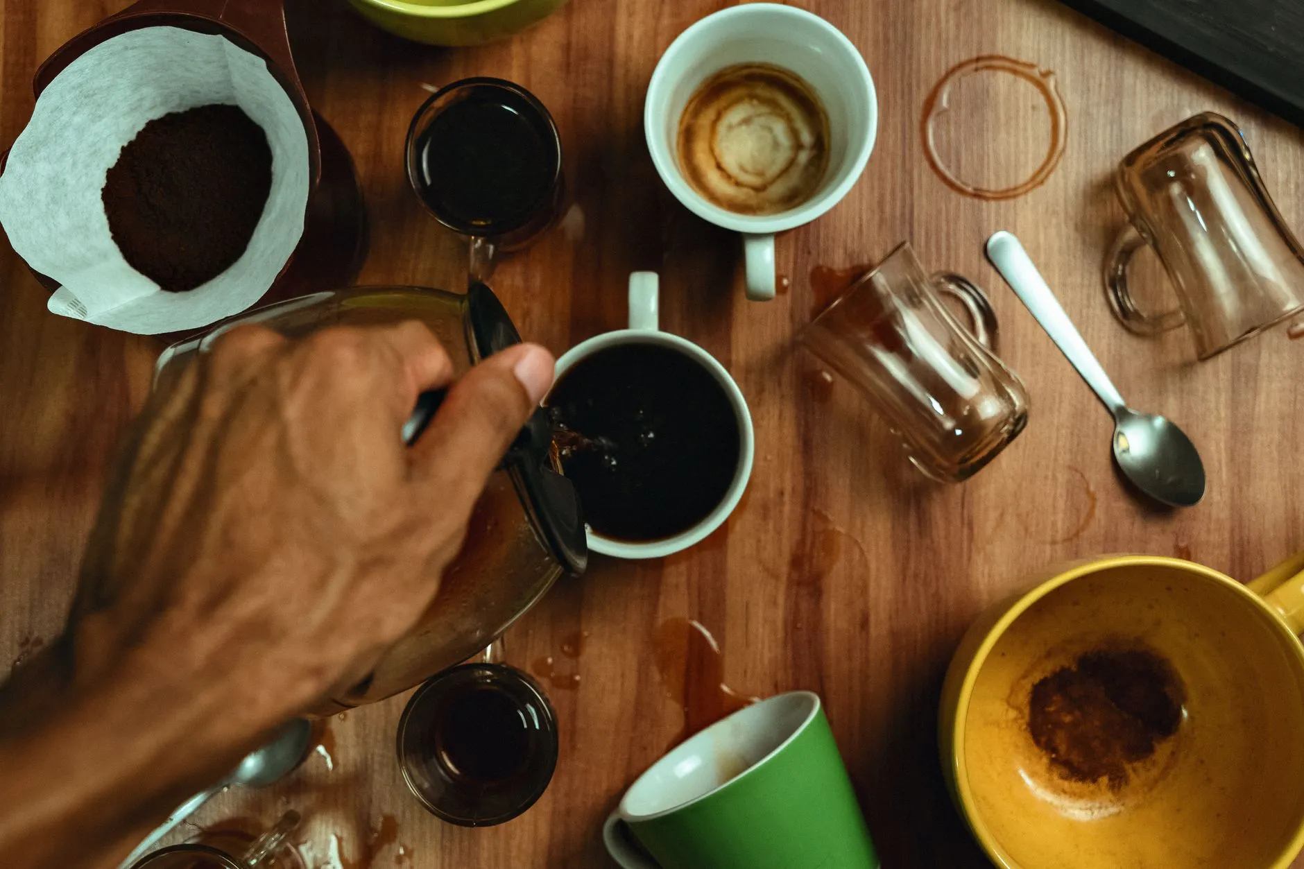 Close up of hands using a tablet to study digital flashcards on a messy dorm room desk with a coffee mug