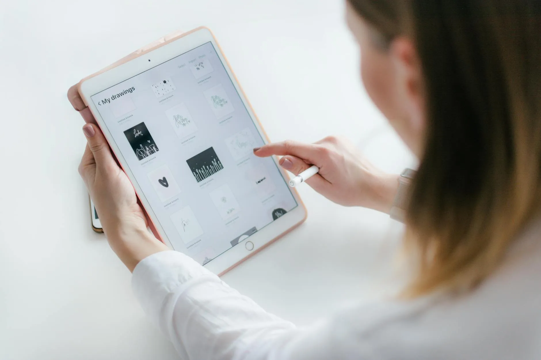 Close-up of student's hands interacting with a flashcard app on a tablet at a messy dorm desk.