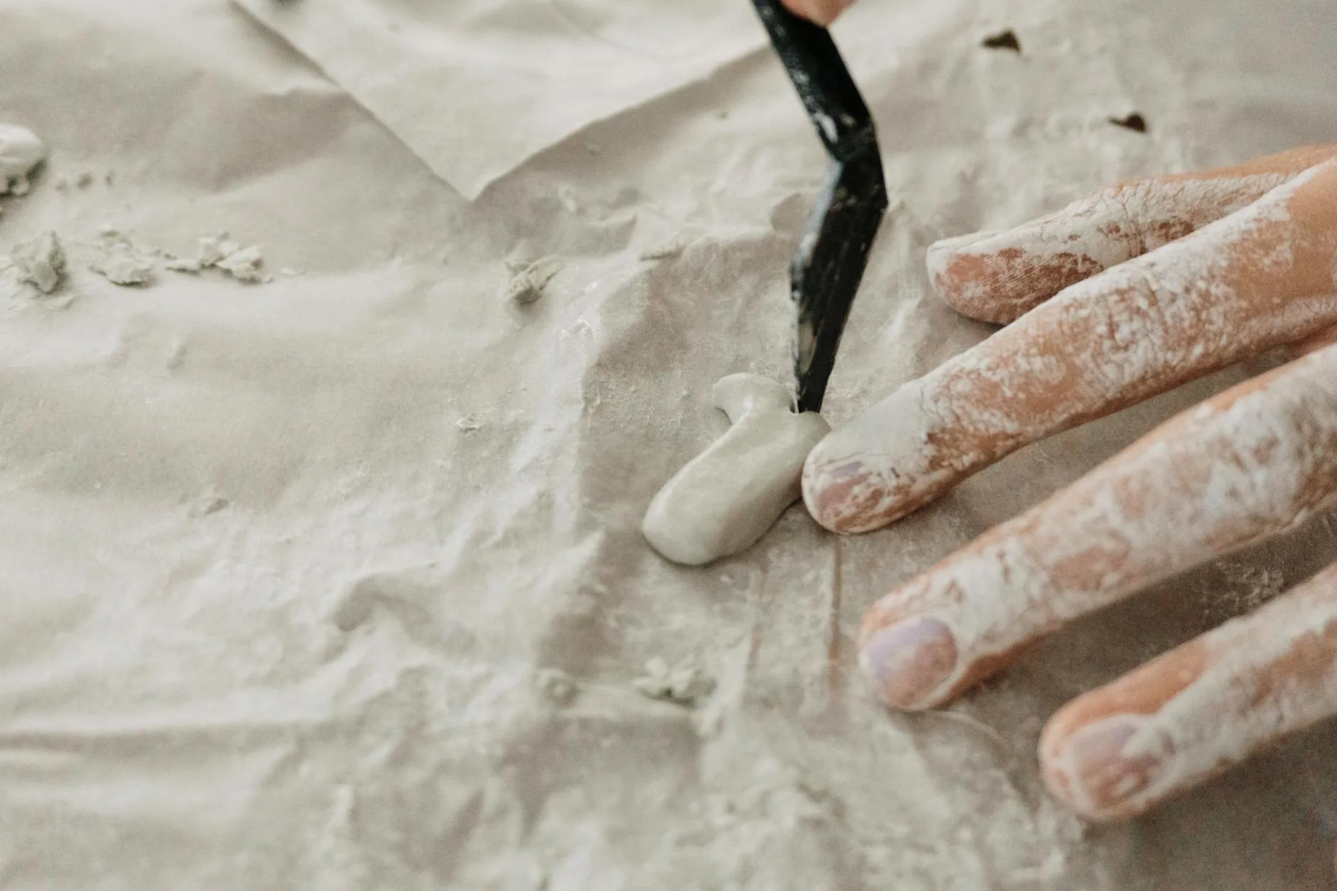 Close up of a student using a tablet to create digital study notes on a messy dorm room desk