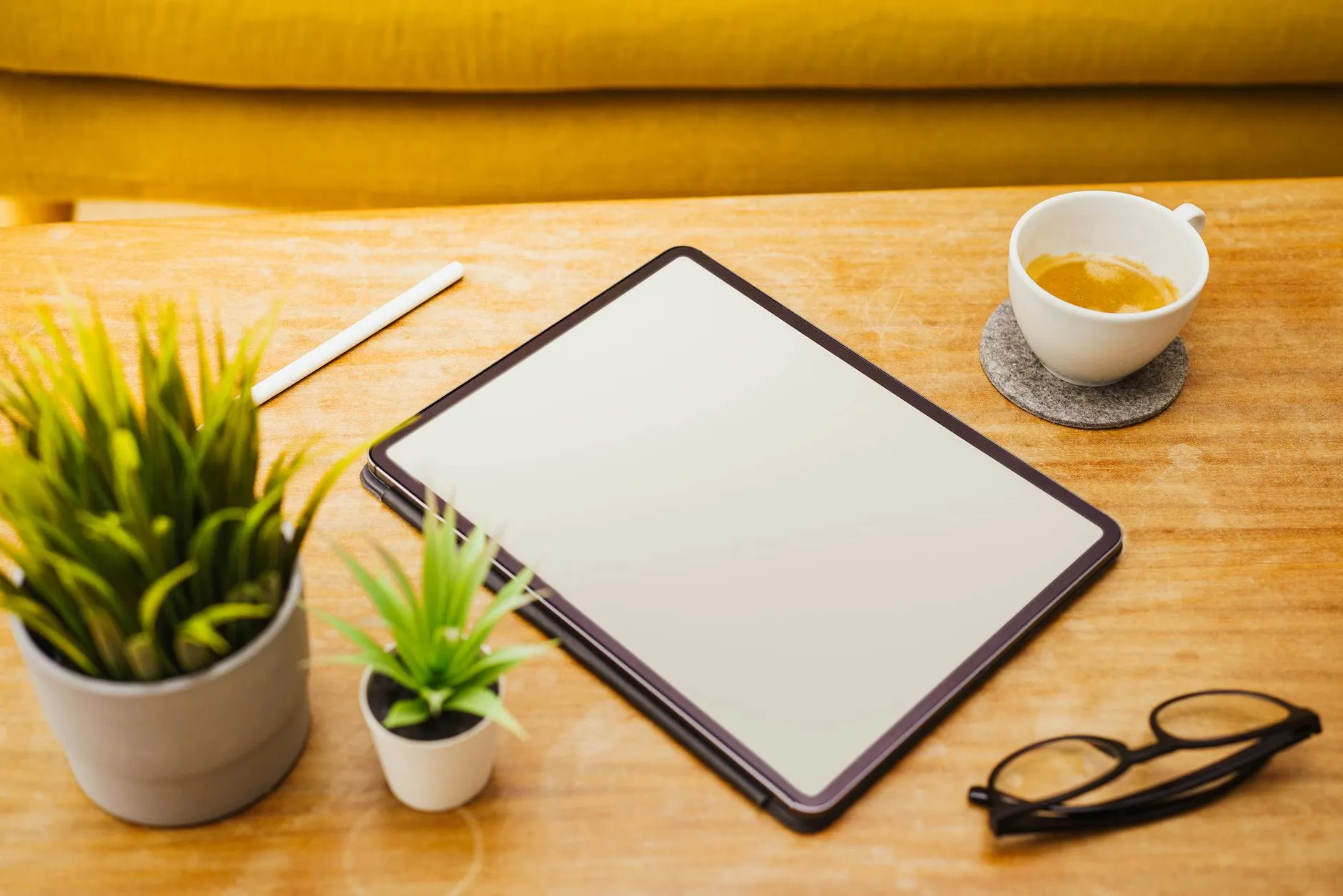Close-up of a student's hands creating digital flashcards on a tablet amidst a slightly disorganized dorm room desk, reflecting active study.