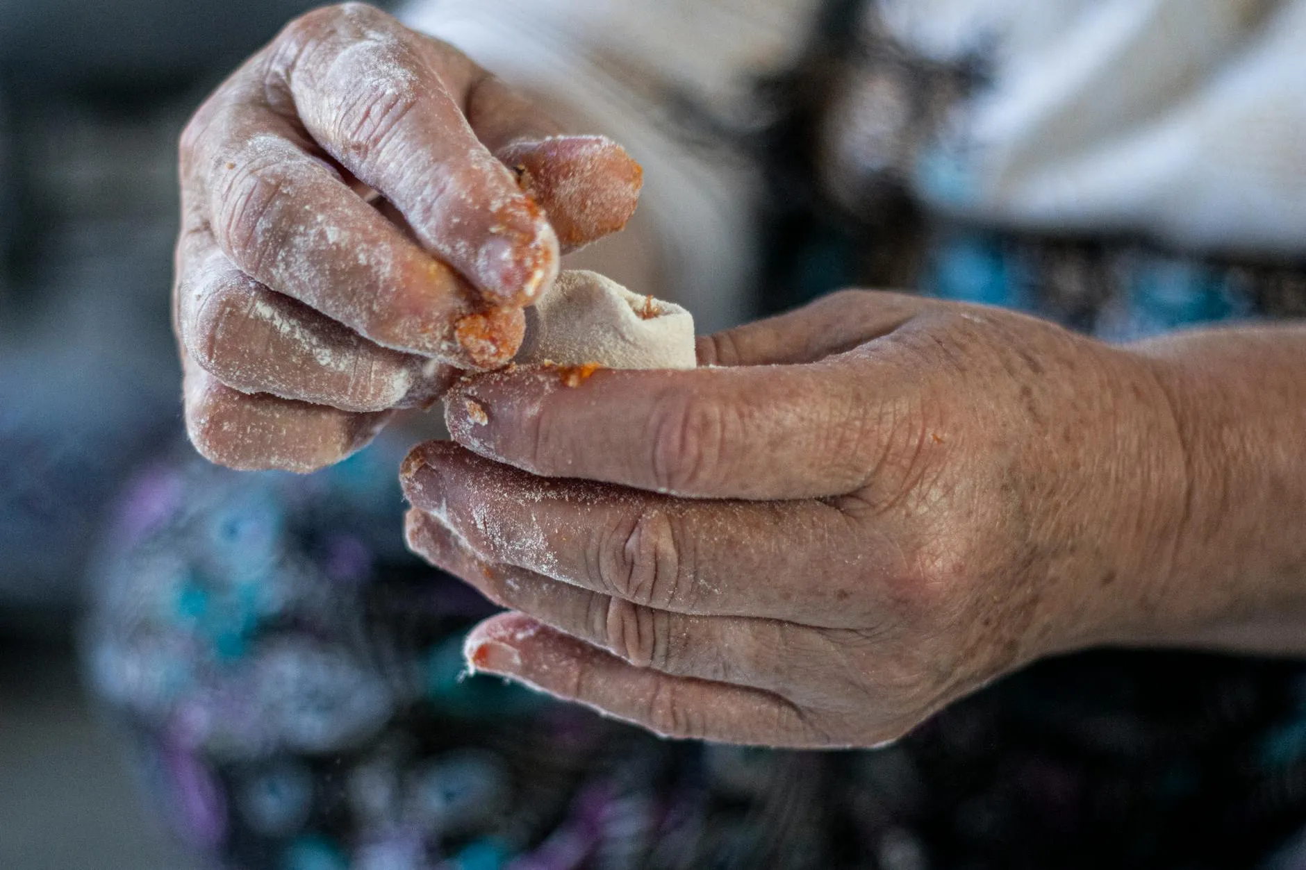 Close-up of a student's hands creating digital flashcards on a tablet amidst a messy dorm room desk.