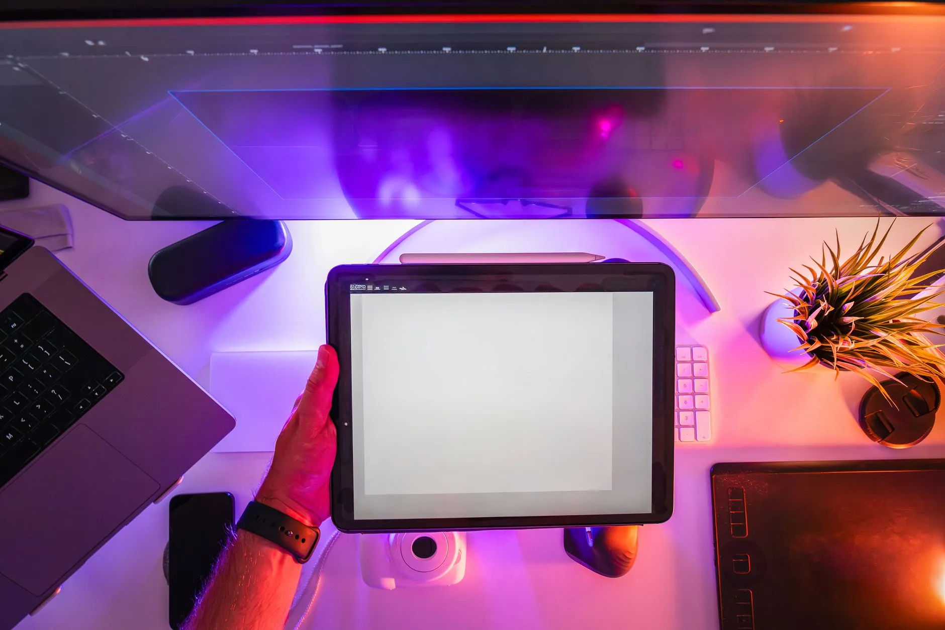 Close up of student hands using a tablet to generate study materials on a messy wooden dorm desk