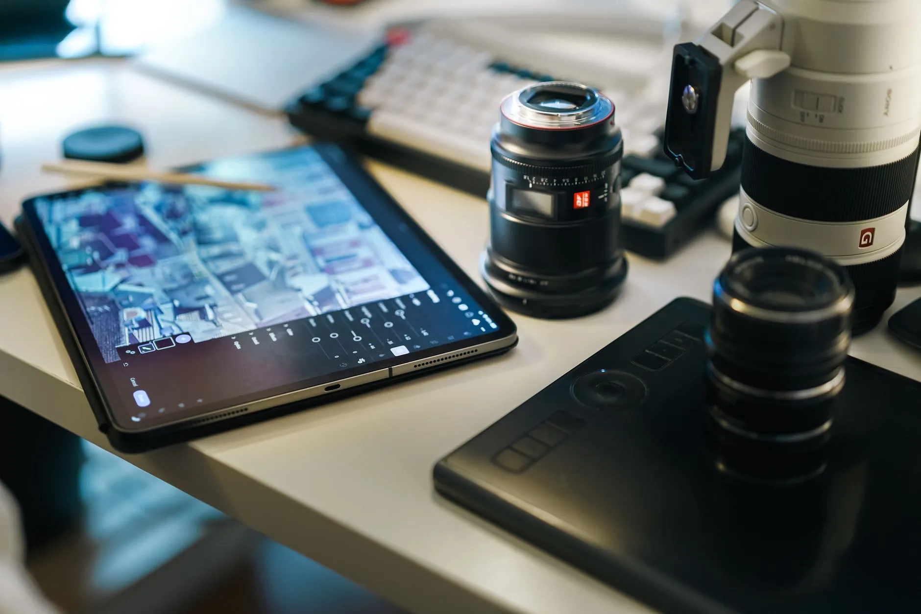 Close up of a student using a tablet to study at a messy dorm room desk with warm lighting