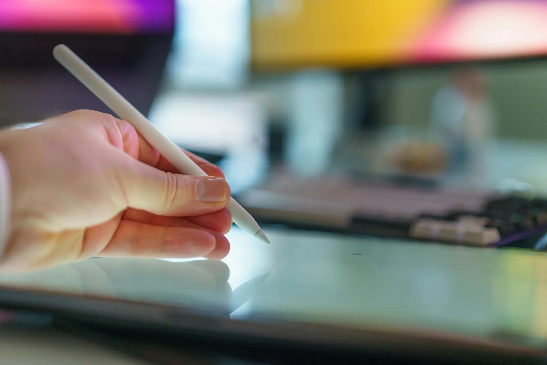 Close up of a student using a tablet and notebook to study at a messy dorm desk