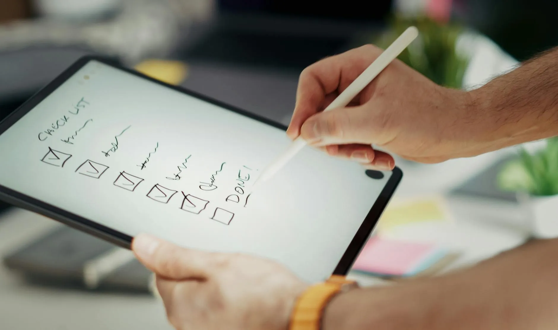 Close up of student hands using a tablet to study on a messy dorm desk