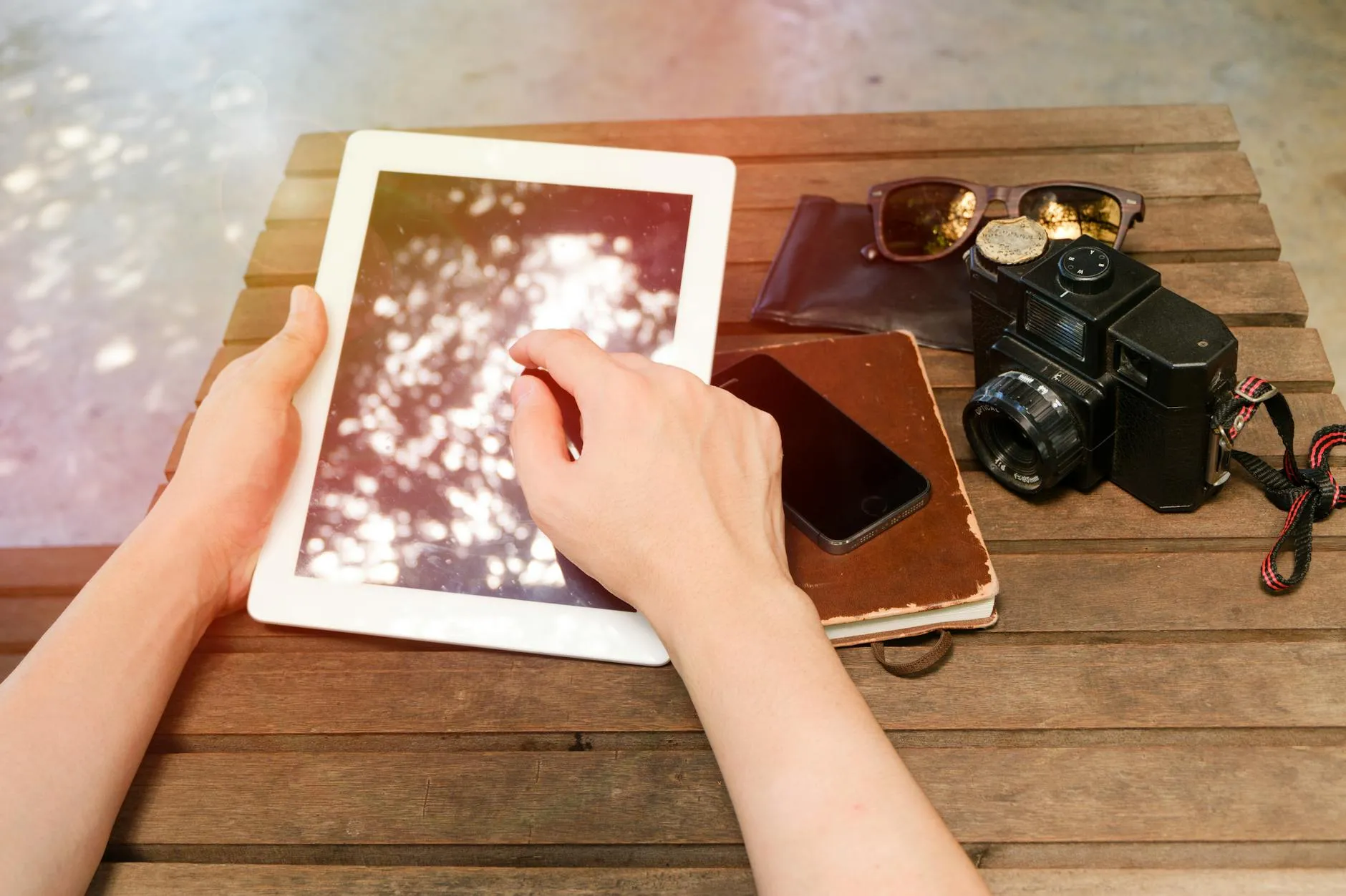 Close up of a student using a tablet to organize study notes on a cozy wooden desk