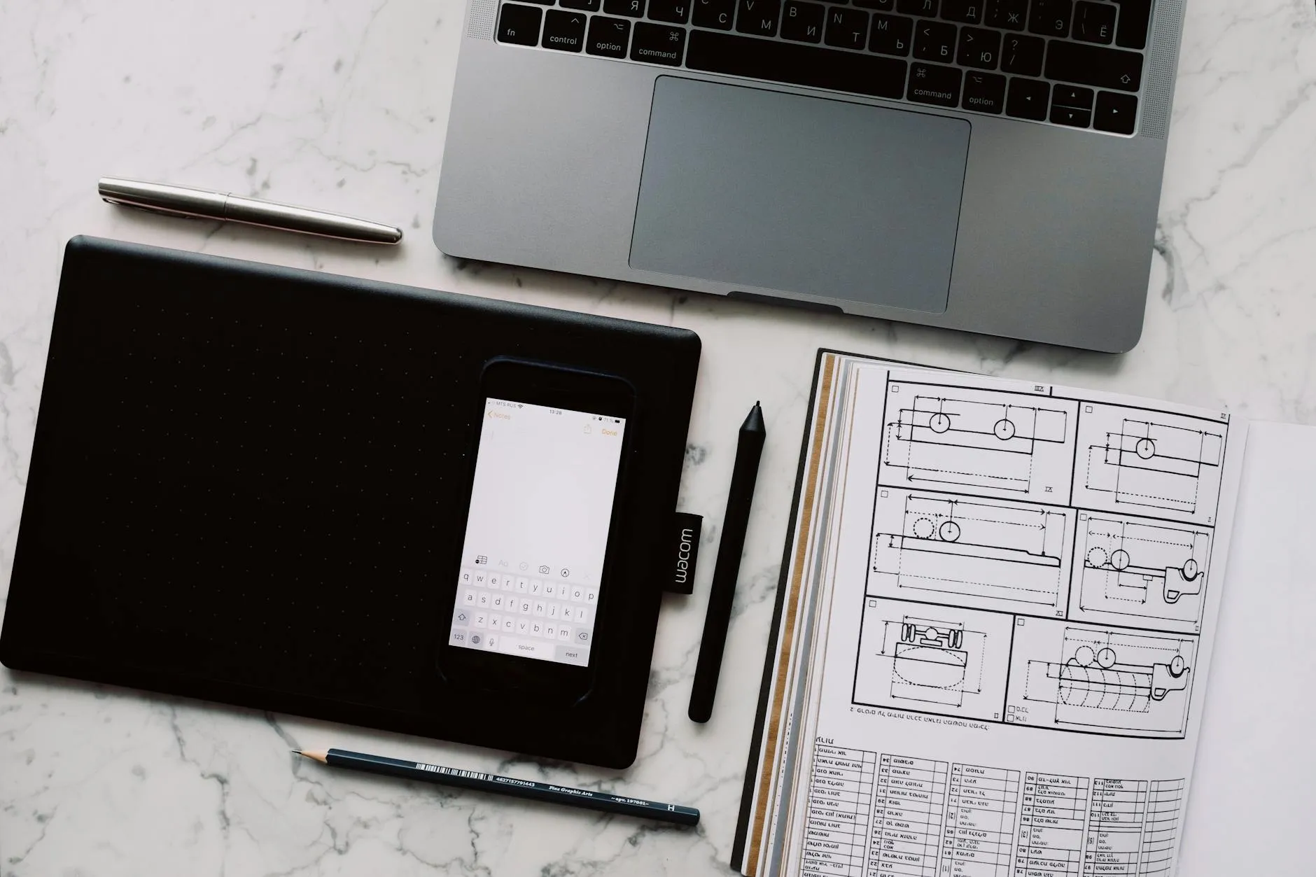 Close-up of a student's hands creating digital flashcards on a tablet at a messy dorm desk.