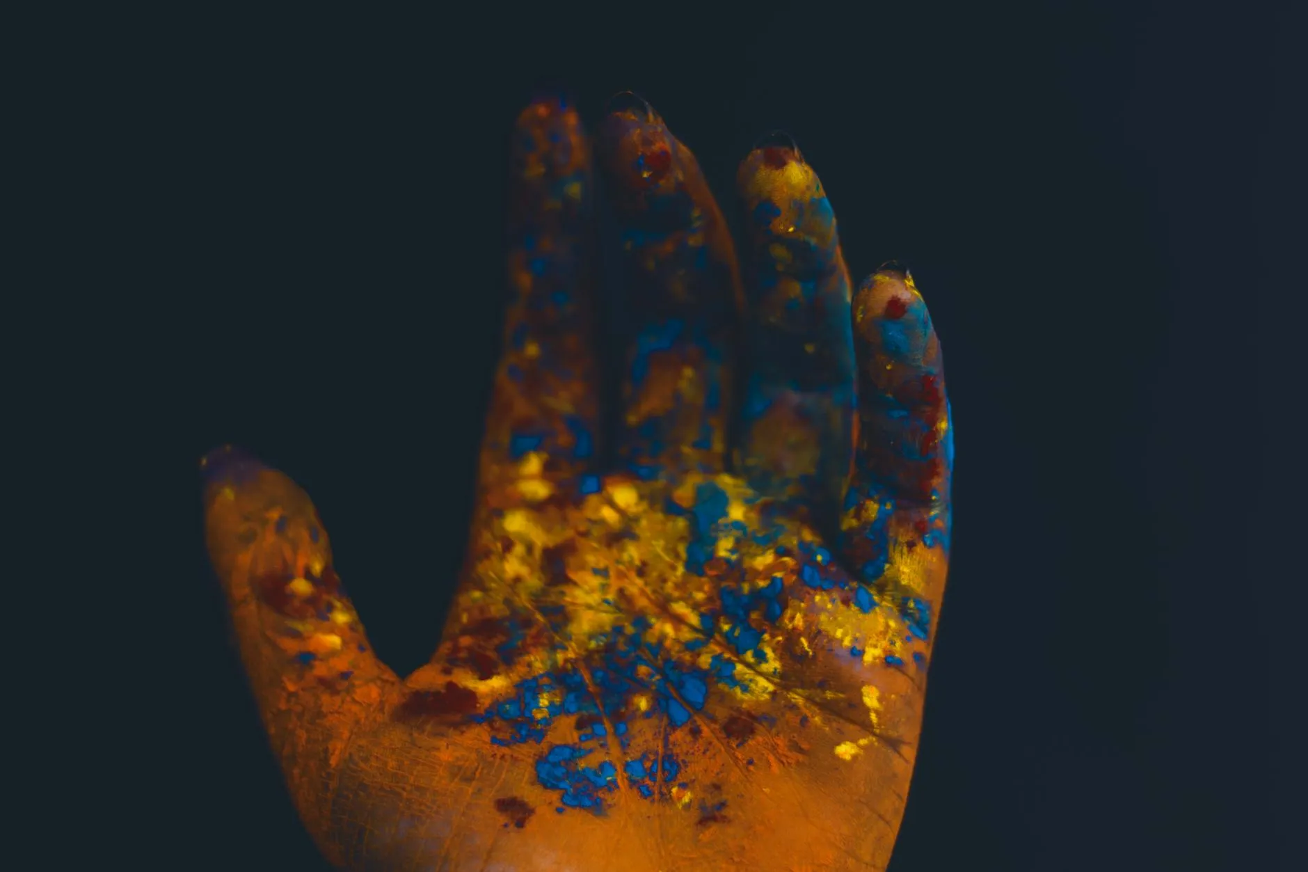 Close-up of a student's hands creating digital flashcards on a tablet at a messy dorm desk