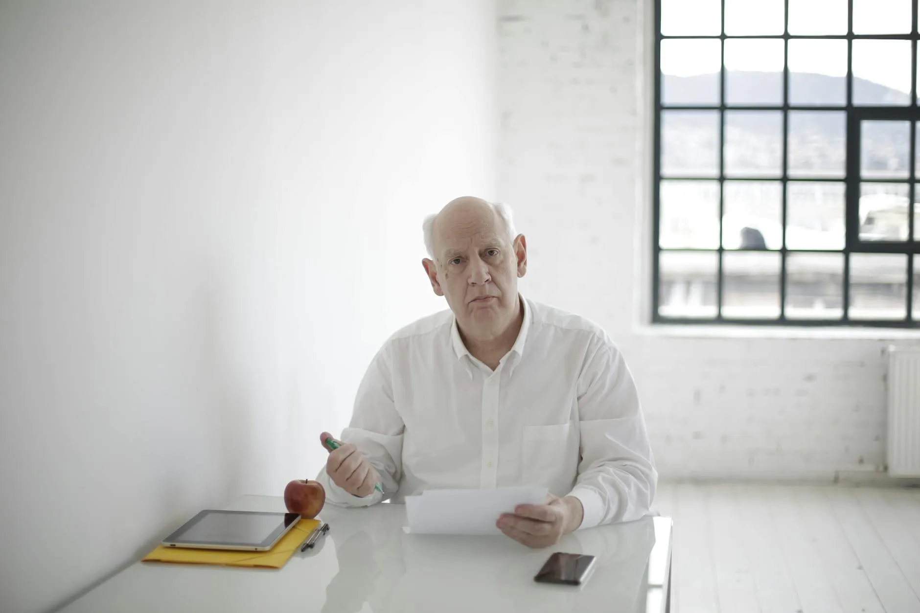 Close-up of a student's hands creating digital flashcards on a tablet, surrounded by notes and a coffee cup on a messy dorm desk.
