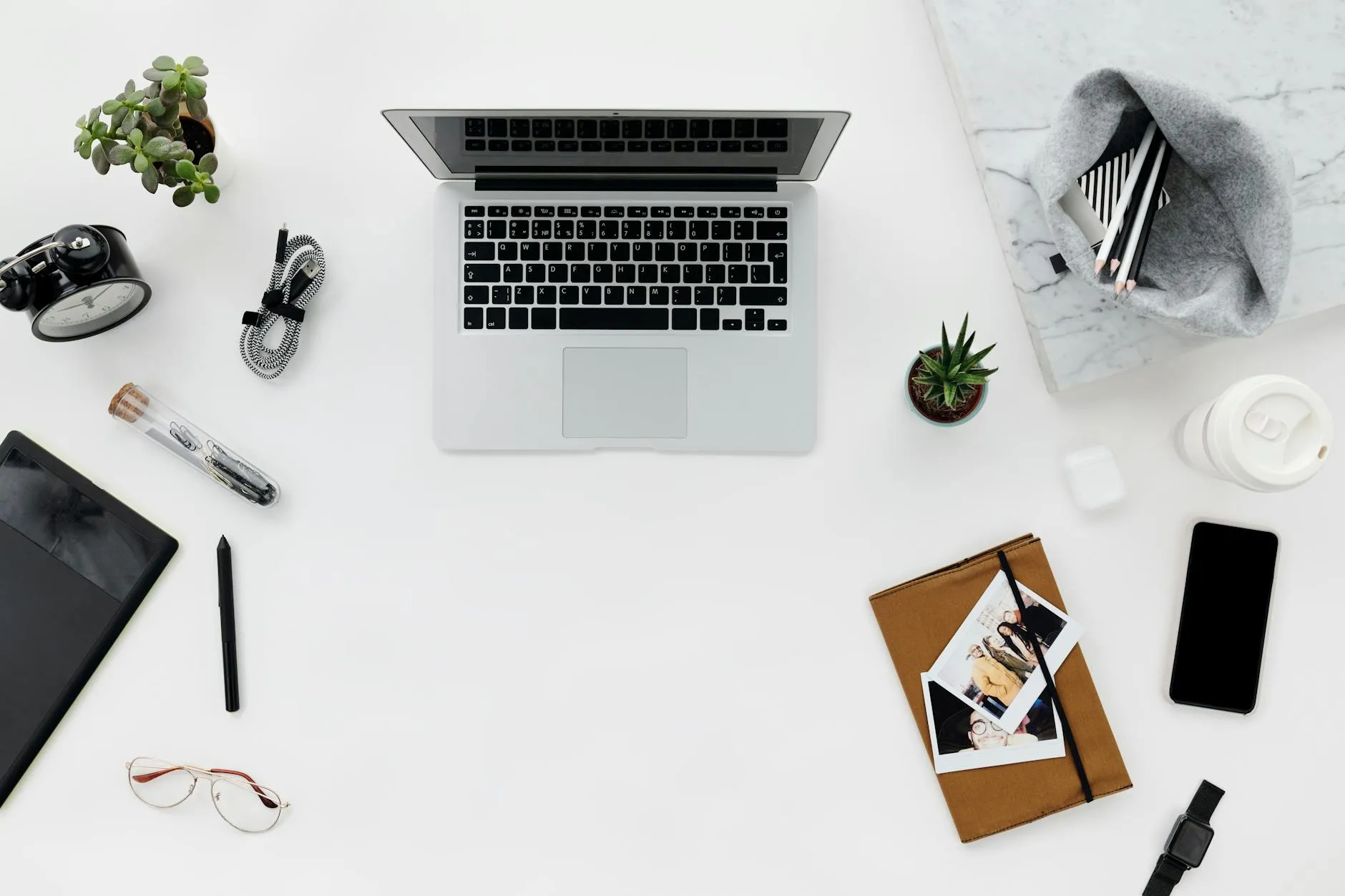 Close-up of student's hands creating digital flashcards on a tablet at a cluttered desk