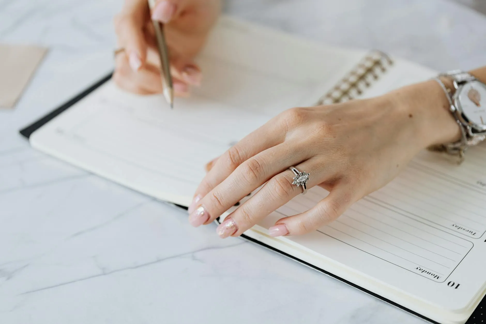 Close-up of a student's hands organizing handwritten flashcards on a cluttered dorm room desk