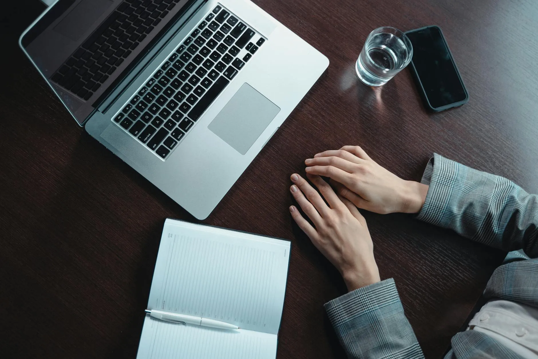Close-up of student's hands creating flashcards on a tablet at a messy dorm desk