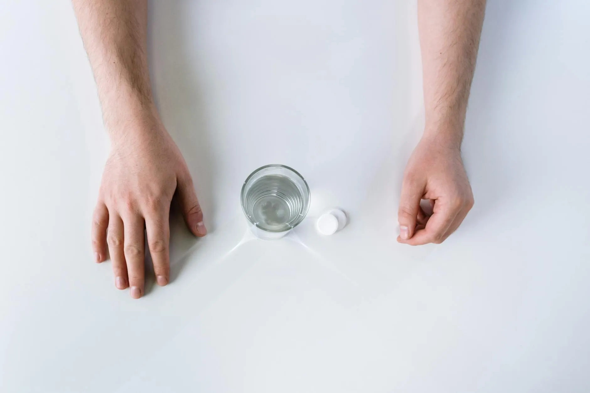 Close-up of a student's hands creating digital flashcards on a tablet at a cluttered dorm desk