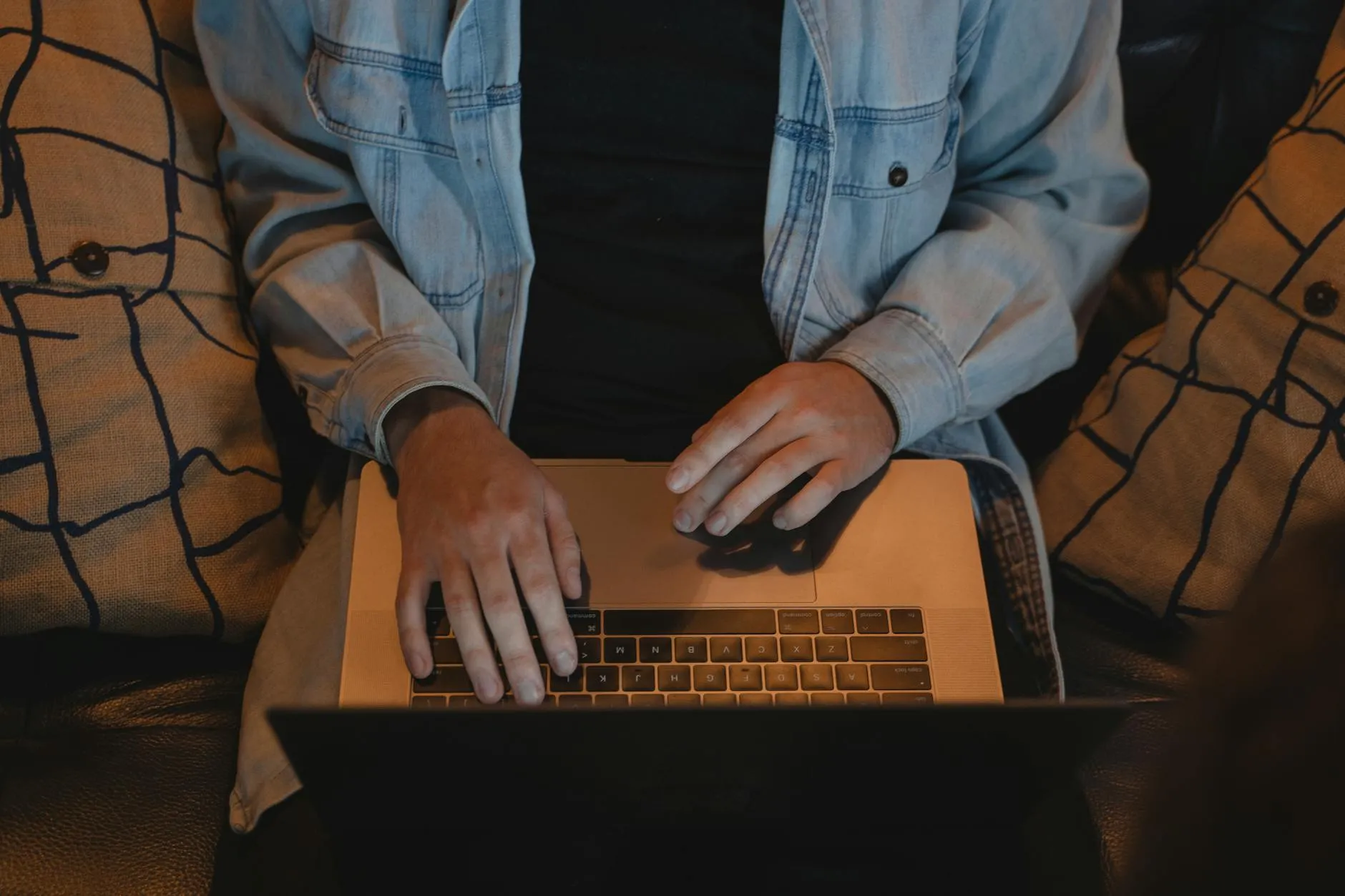 Close up of a student hands typing on a laptop on a messy desk with coffee and notebooks