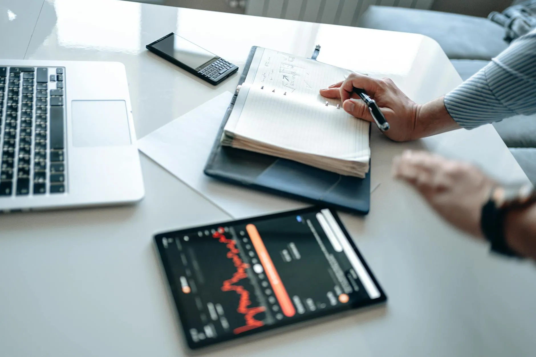 Close up of a student using a tablet to create study materials on a messy desk