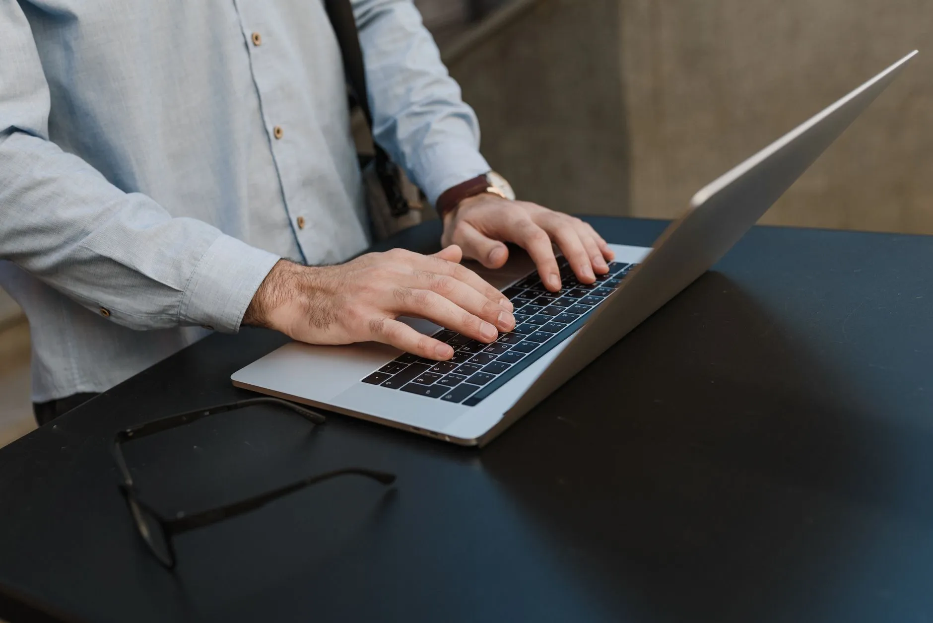Close up of hands typing on a laptop keyboard during a university lecture