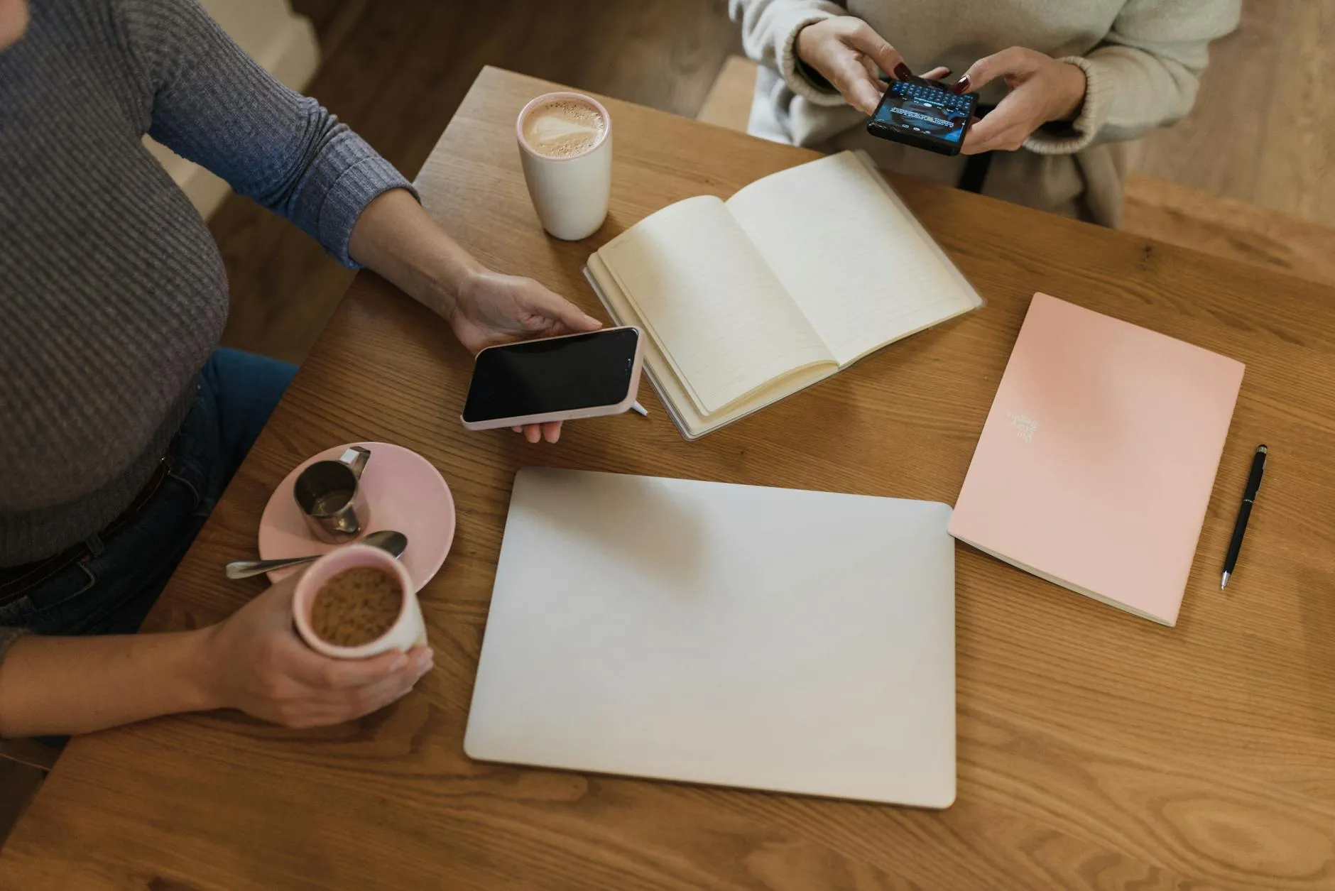 A Gen Z student focused on their laptop in a busy campus coffee shop during the day