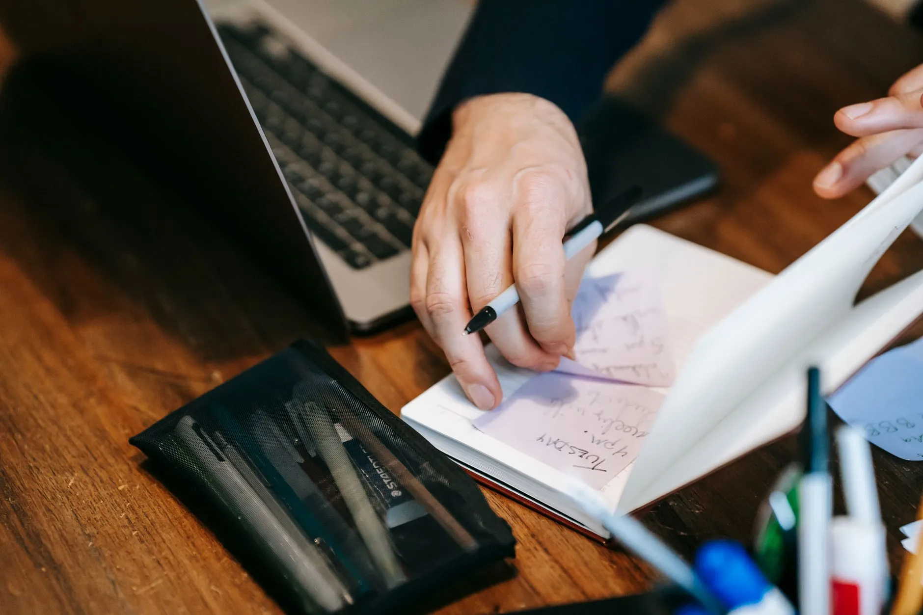 Close up of a student hands creating digital flashcards on a tablet at a messy dorm desk