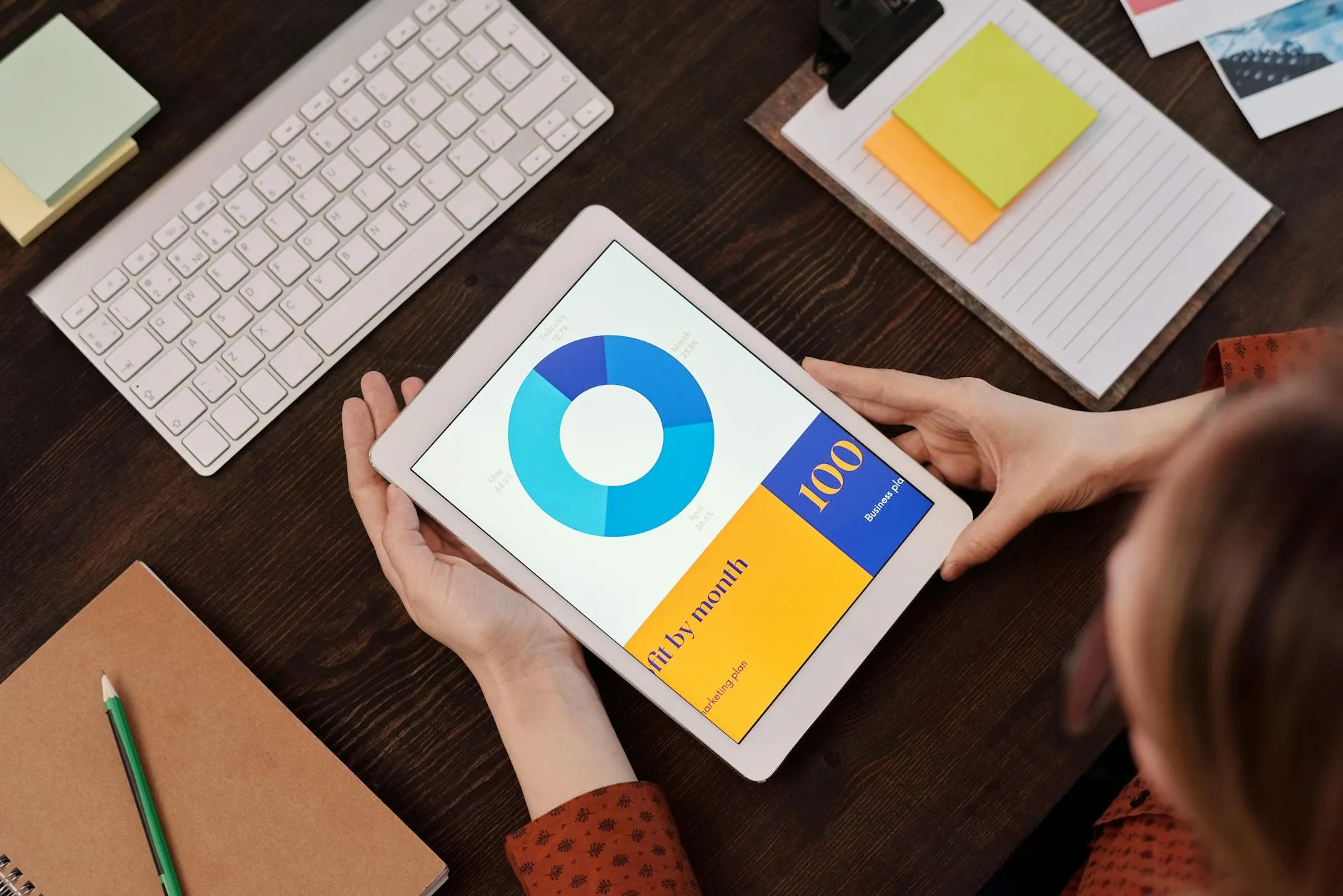 Close-up of student's hands using an AI flashcard maker on a tablet amidst study materials