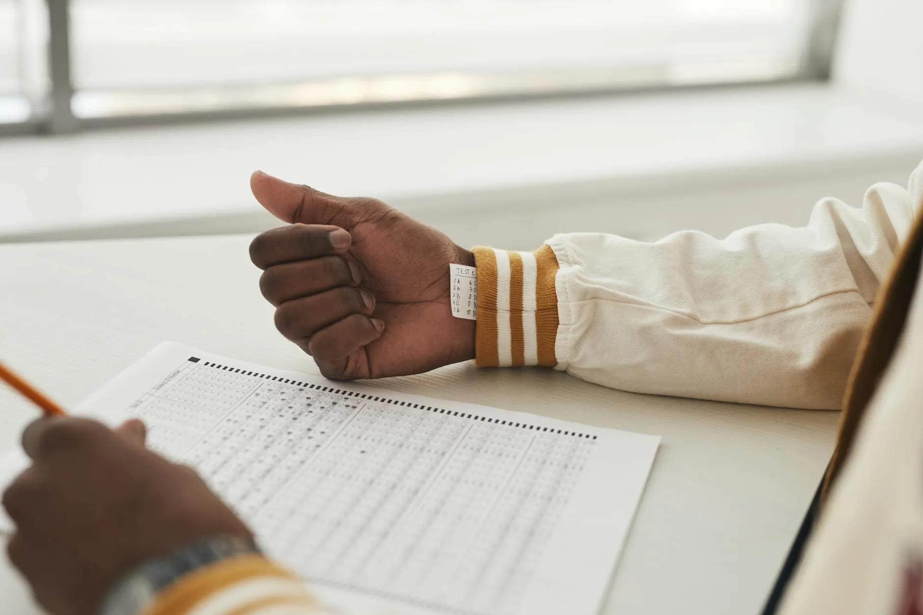 Close-up of a student's hands typing notes into an AI quiz generator on a laptop in a cozy dorm room.