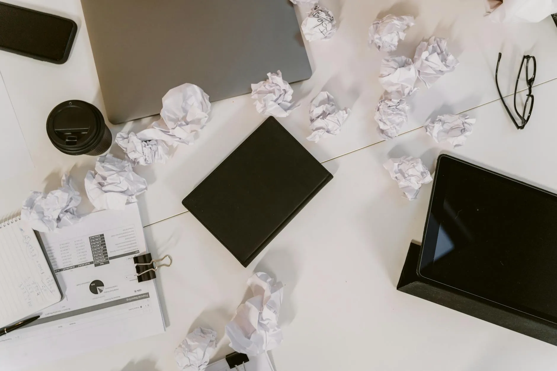 Close up of a student using a tablet to create digital flashcards on a messy dorm room desk