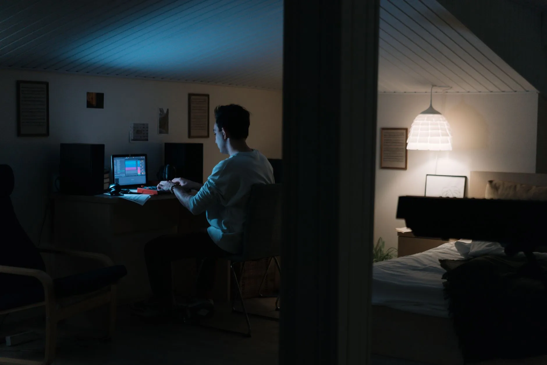 A cozy student desk with a laptop and notebook illuminated by an evening lamp