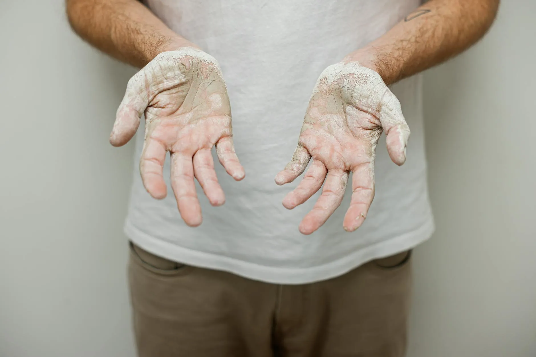 Close-up of student's hands making digital flashcards on a tablet amidst a messy dorm desk