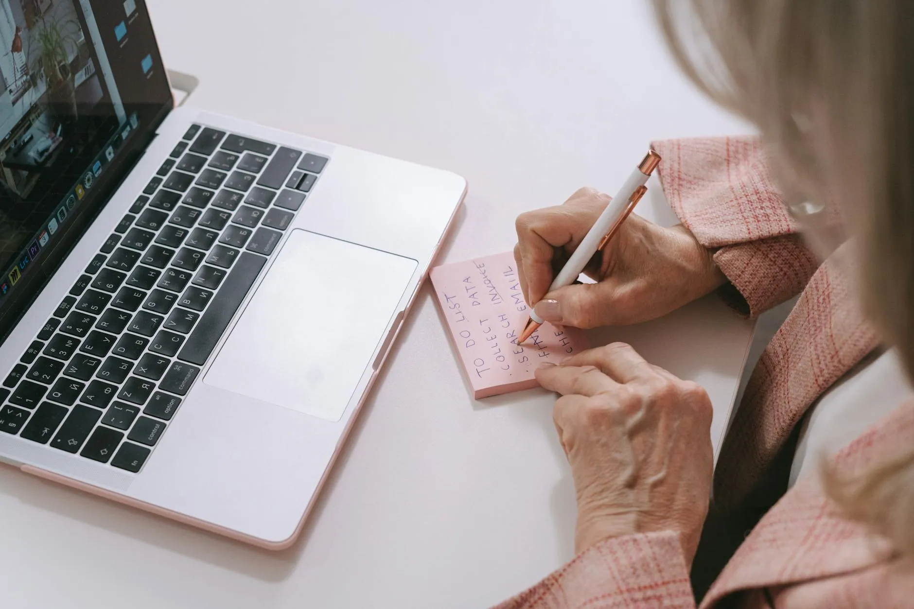Close-up of a student's hands organizing digitized notes on a laptop in a cozy dorm room.