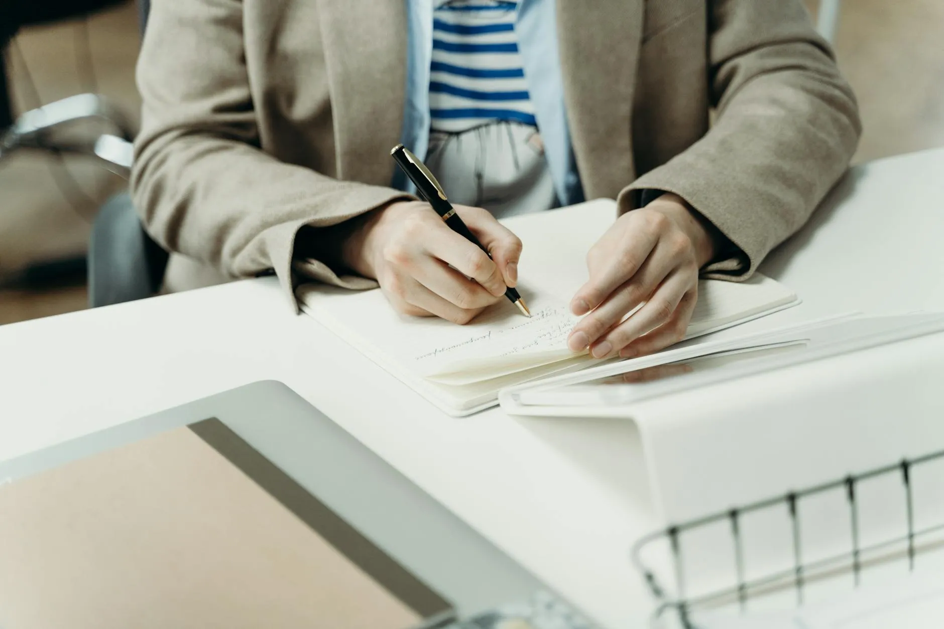 Close-up of student's hands creating digital flashcards on a tablet at a cluttered dorm room desk