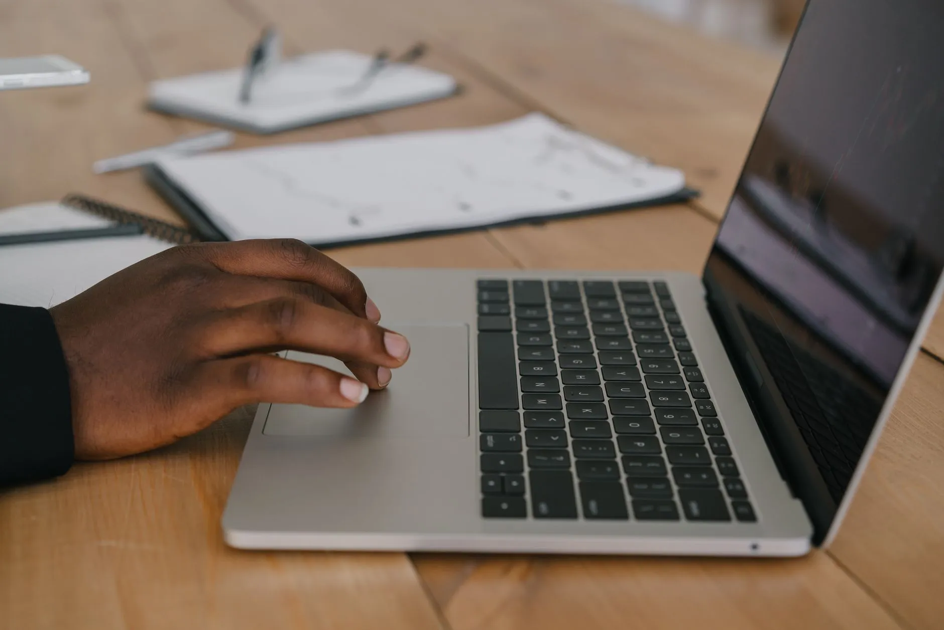 Close up of hands typing on a laptop keyboard with lecture slides open on the screen