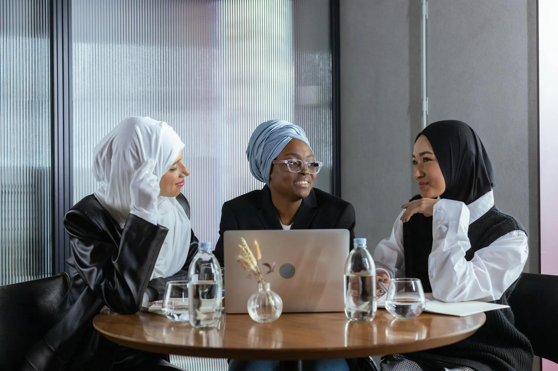 A group of diverse university students talking and laughing in a bright modern campus coffee shop