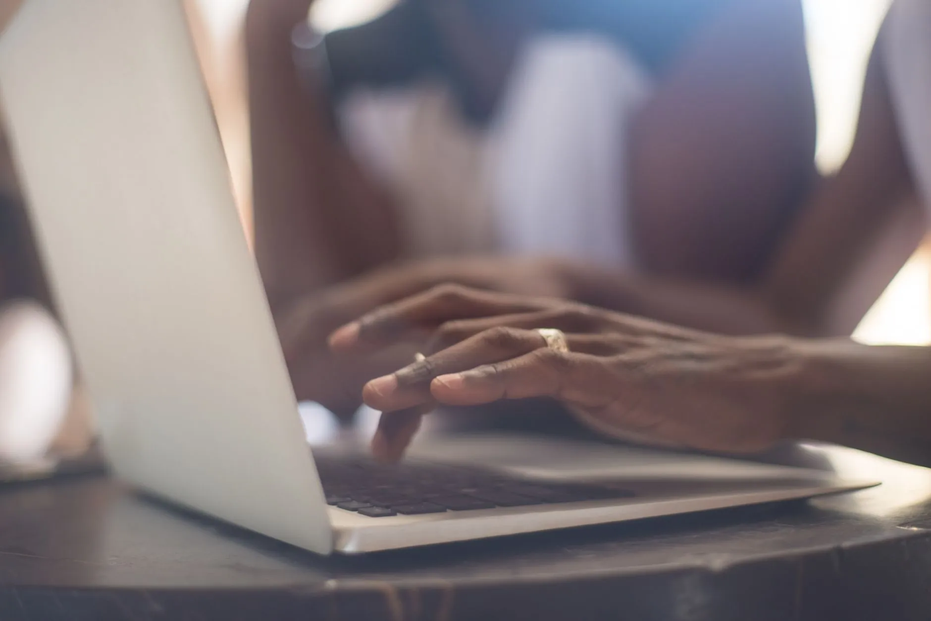 Close up of hands typing on a laptop keyboard with digital study tools open on the screen