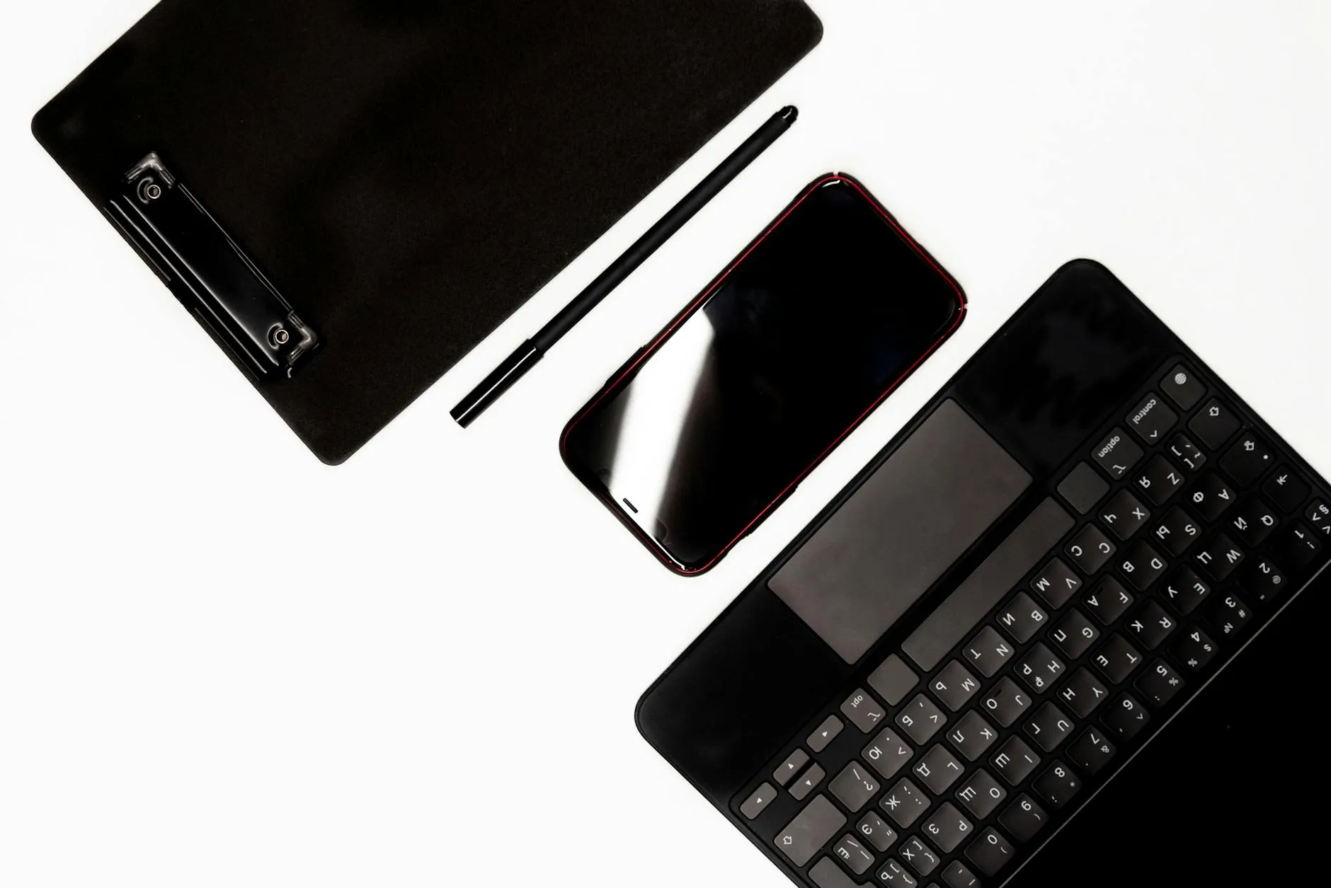 Close-up of a student's hands creating digital flashcards on a tablet amidst a messy but organized dorm desk.