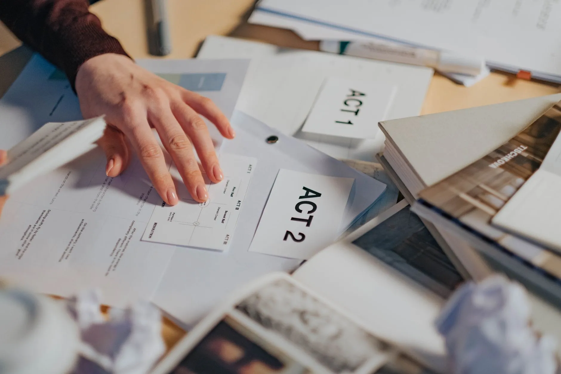 Close up shot of a student hands using a tablet to create digital flashcards on a messy dorm room desk