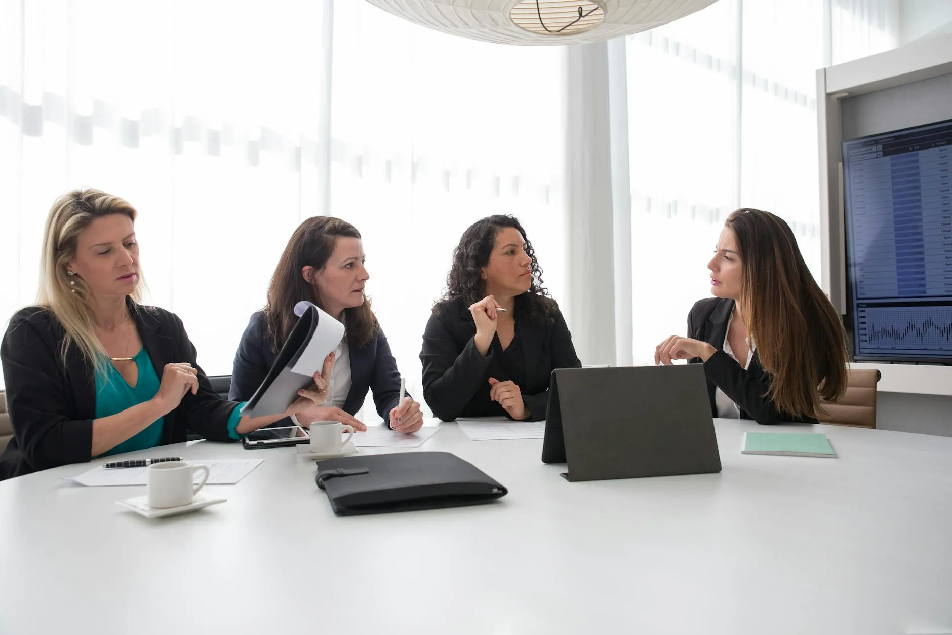 Close-up of a student's hands creating digital flashcards on a tablet at a messy dorm room desk.