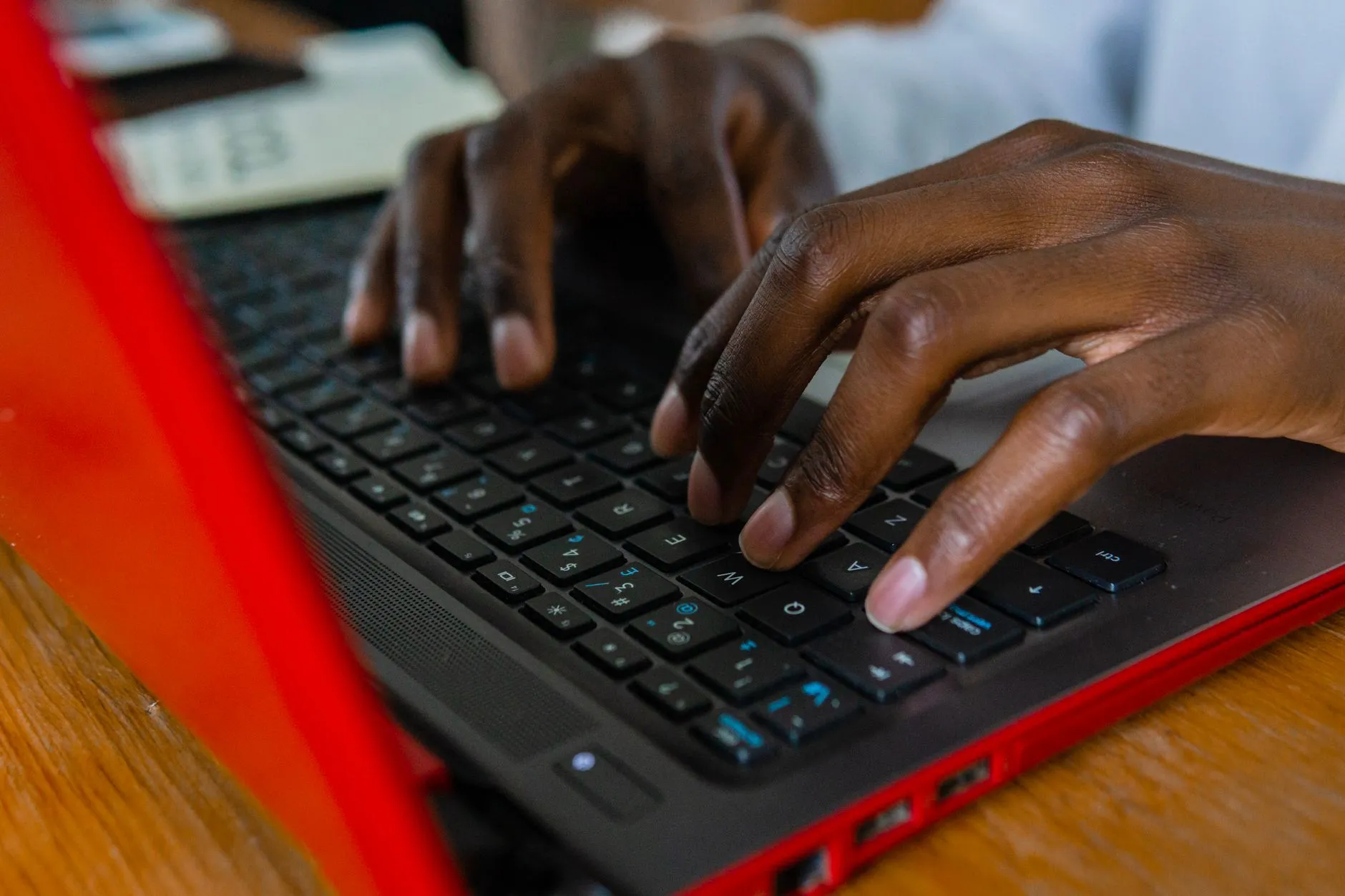 Close up of student hands typing notes on a laptop during a university lecture