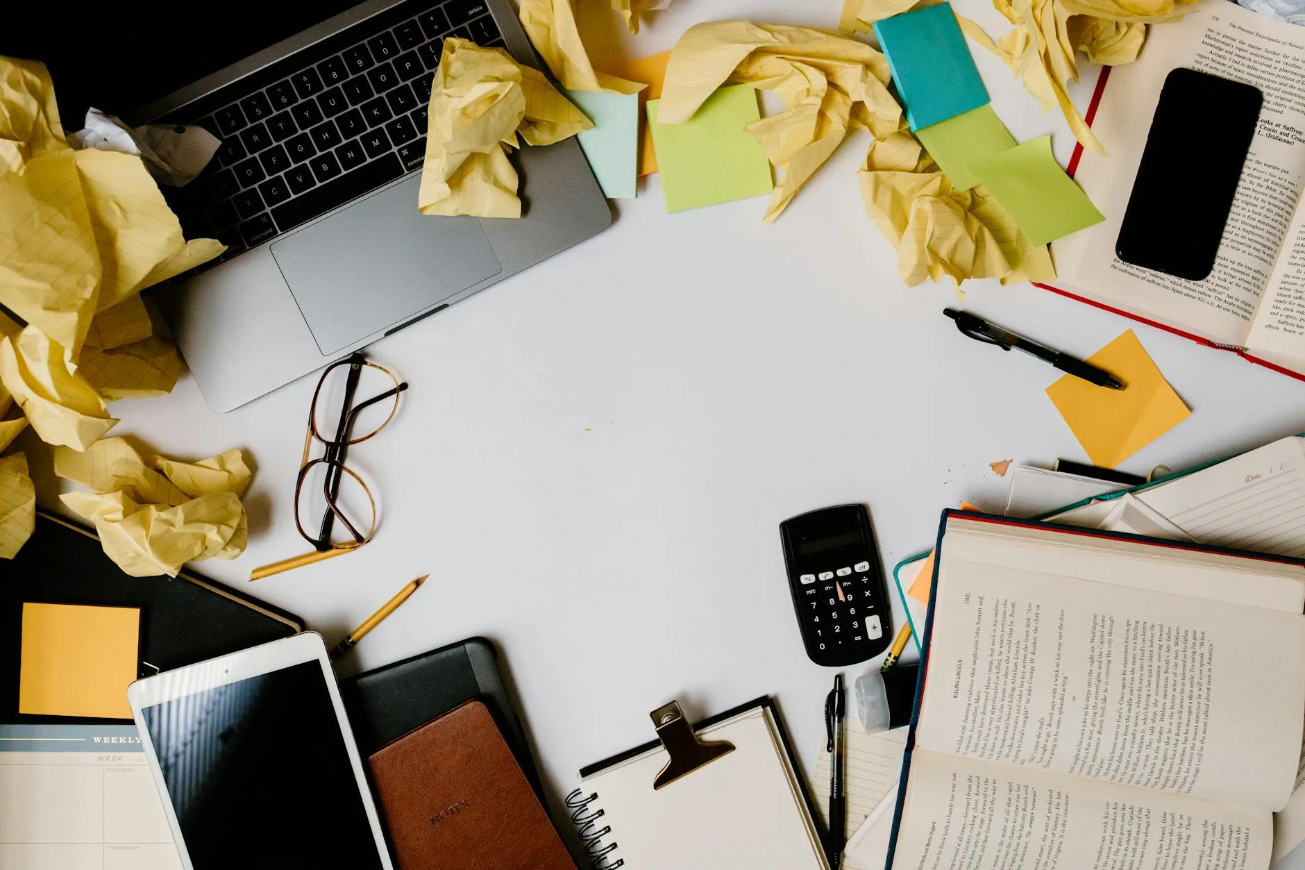 Close up of a student using a tablet to create digital flashcards on a messy dorm room desk