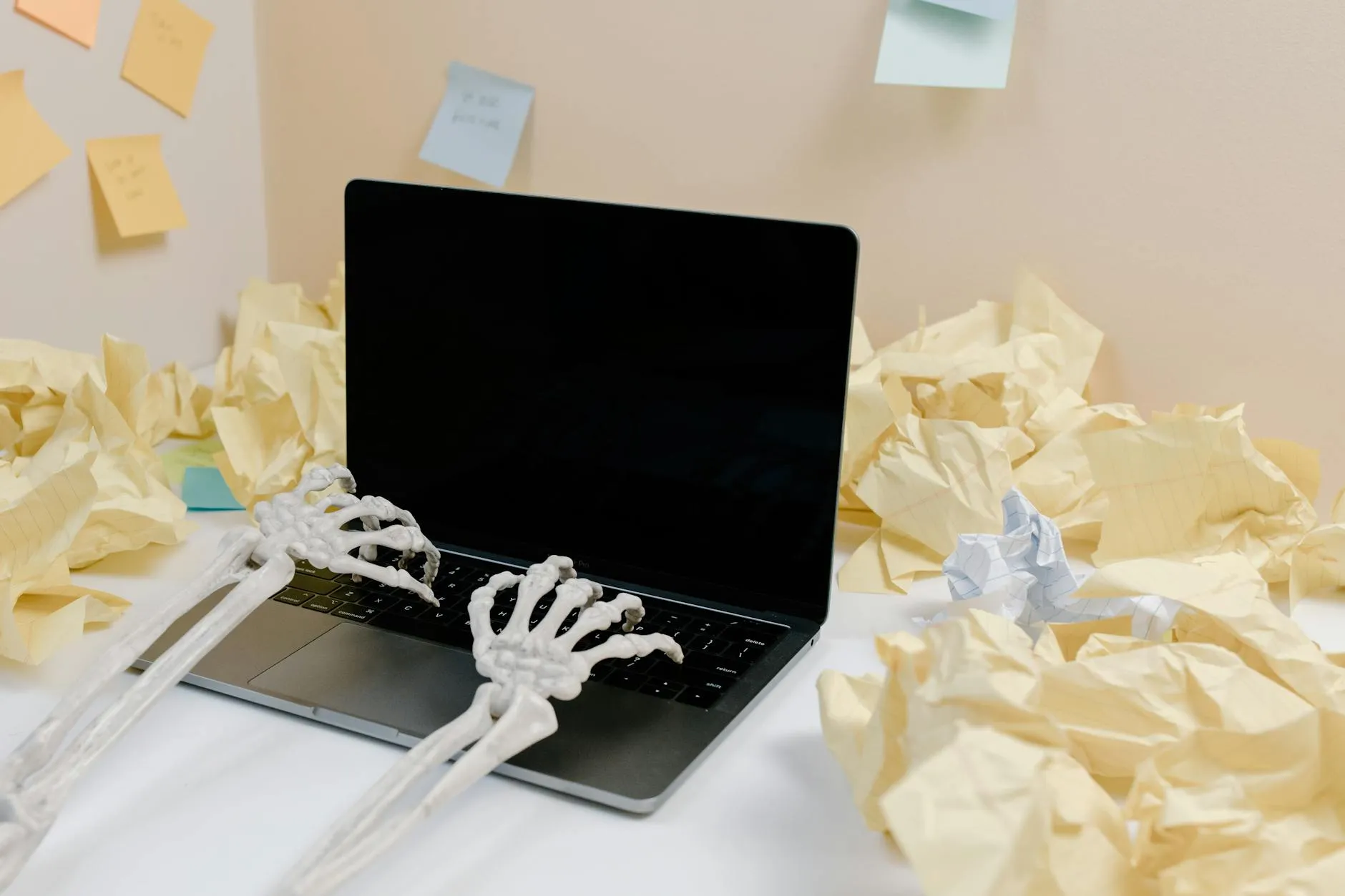 Close-up of a student's hands typing lecture notes into a quiz generator on a laptop at a messy dorm desk.